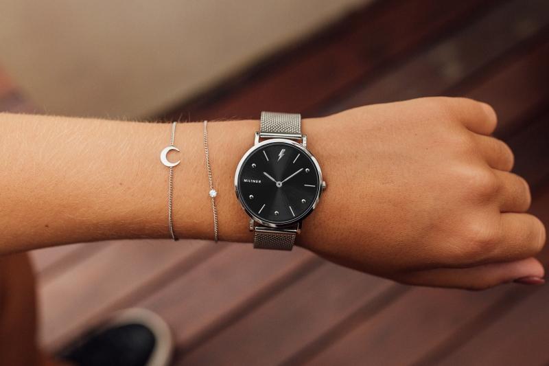 Stříbrné hodinky s černým ciferníkem.